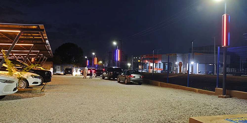Parking area lighting project with a line of pole-mounted lights extending into the distance