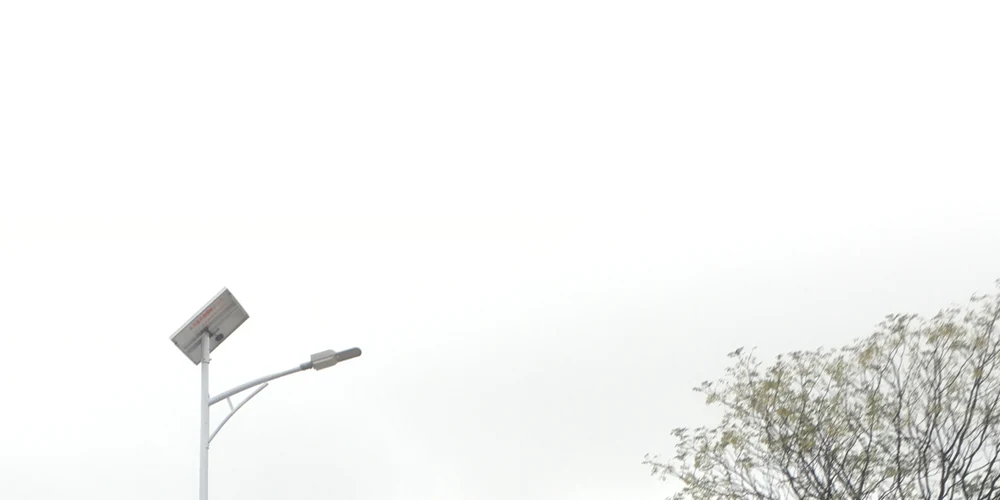 YY Series solar street light under an overcast sky showing its solar panel and LED lamp head