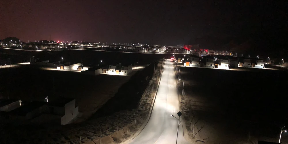 Rural road illuminated by pole-mounted solar street lights at night